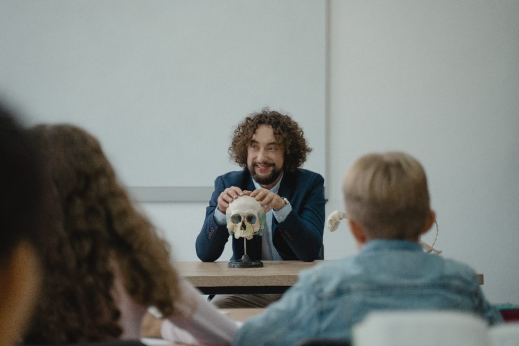 Man with a skull in front of students